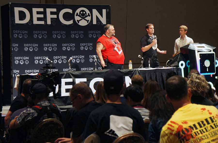 Rogers and Mahaffey (left to right) explain at a Def Con event, what Tesla does right and where the weakness was in designing the Model S' information systems