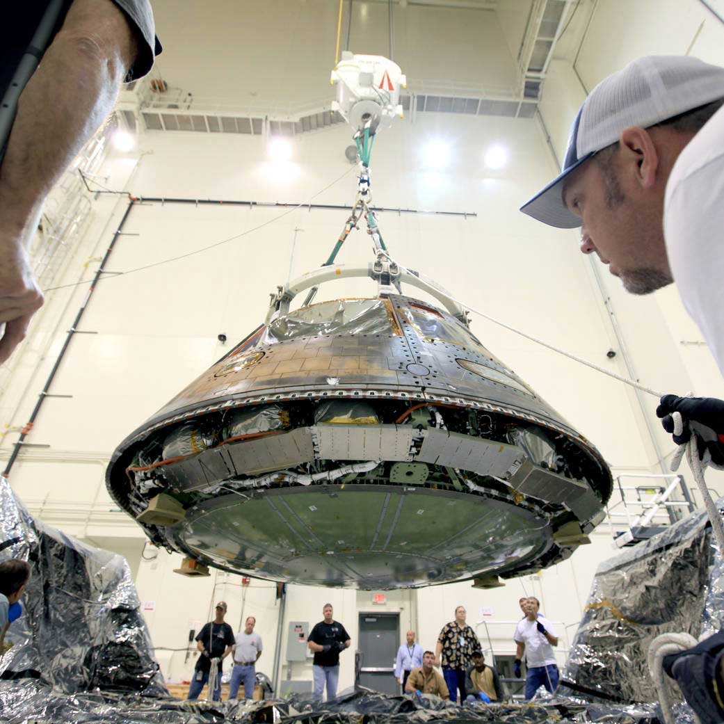 Inside the Launch Abort System Facility at NASA’s Kennedy Space Center in Florida, workers are preparing the Orion spacecraft that flew on Exploration Flight Test-1 in 2014 for transport to Orion prime contractor Lockheed Martin's facility in Denver, where it will undergo direct field acoustic testing. Photo credit: NASA/Kennedy