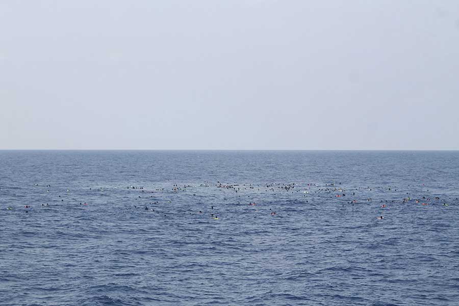 Surviving migrants are seen swimming in the Mediterranean after a wooden boat packed with up to 700 people capsized and sank off the coast of Libya on 5 August 2015(Italian Police/Reuters)
