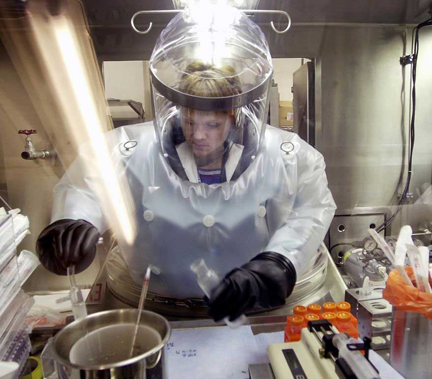 FILE - In this May 11, 2003, file photo, Microbiologist Ruth Bryan works with BG nerve agent simulant in Class III Glove Box in the Life Sciences Test Facility at Dugway Proving Ground, Utah. The specialized airtight enclosure is also used for hands-on work with anthrax and other deadly agents. The Centers for Disease Control and Prevention said it is investigating what the Pentagon called an inadvertent shipment of live anthrax spores to government and commercial laboratories in as many as nine states, as well as one overseas, that expected to receive dead spores. (AP Photo/Douglas C. Pizac, File)